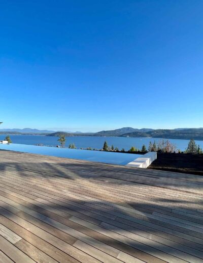 expansive wood patio and infinity pool leading to view of Lake Coeur d'Alene