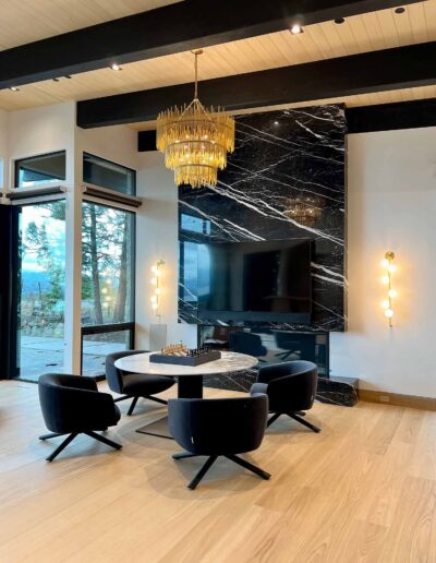 expansive dining room with grey marble table and black marble fireplace mantle