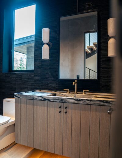 custom dark tile bathroom with illuminated shelving