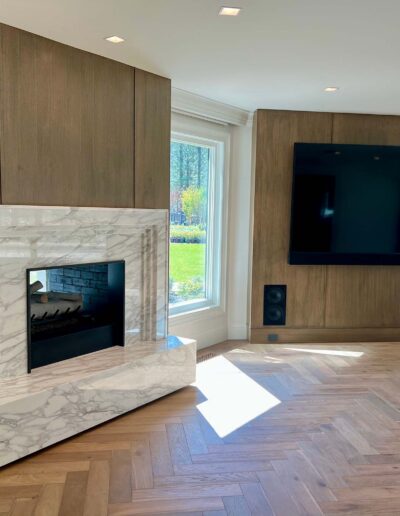 custom entertainment room with marble fireplace and natural flooring and paneling